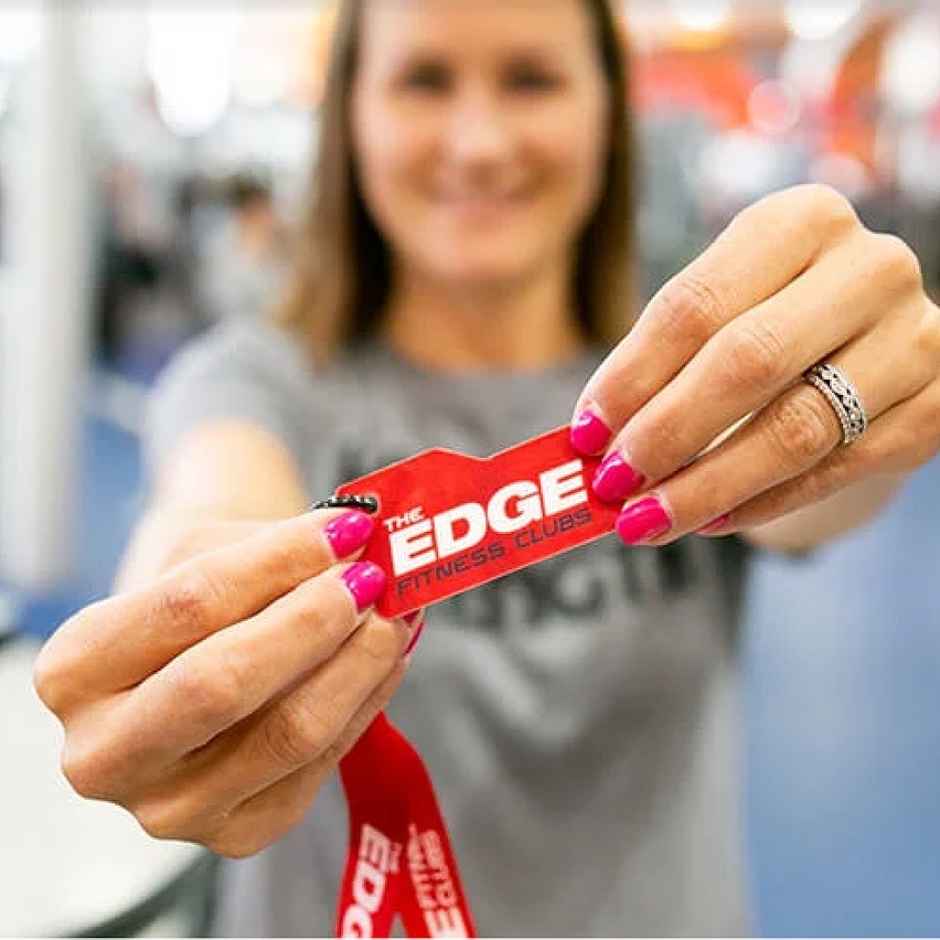 Woman holding Edge Fitness pass.